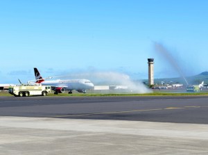 Photo of a Virgin America plane arriving in Maui for the first time under a water arc.