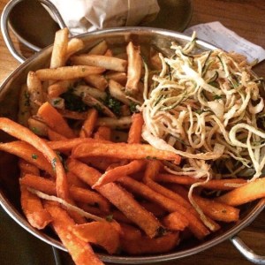 Photo of sweet potato fries in a bowl mixed with regular fries, zucchini and onion.