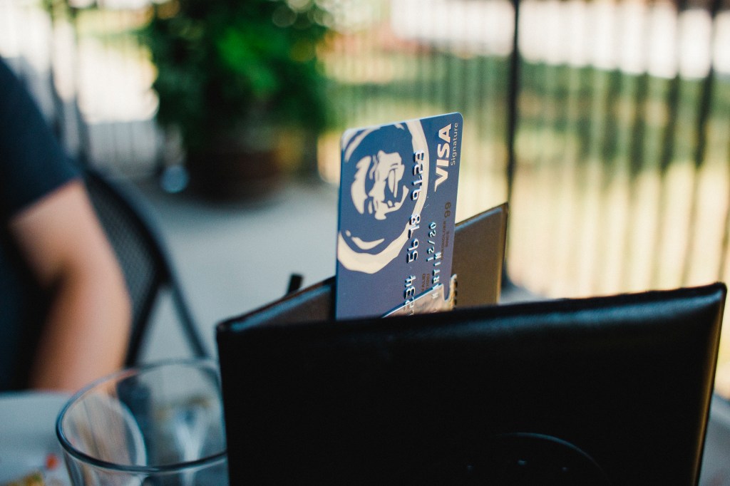 A photo of an Alaska Airlines Visa Signature card sticking out of a billfold on a restaurant table.
