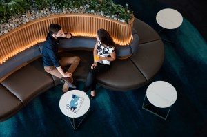 This is a photo of two travelers sitting on a bench in the Qantas lounge.
