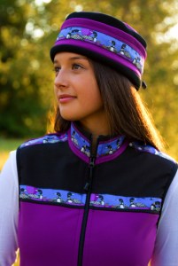 This is a photo of a woman wearing a purple Copper River Fleece vest and matching hat with a songbird trip