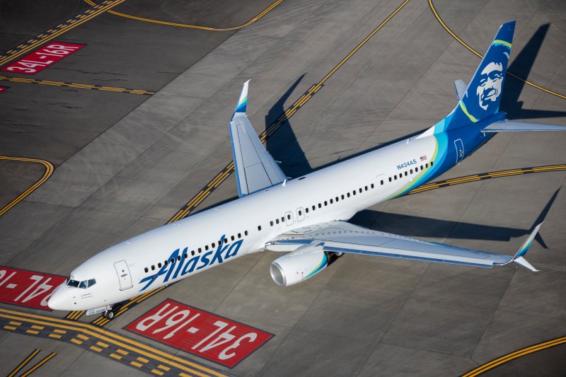 This is a photo of an Alaska Airlines jet taxiing on a runway.
