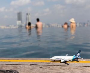 This is a photo of a mini plane overlooking an infinity pool atop the Marina Bay Sands.