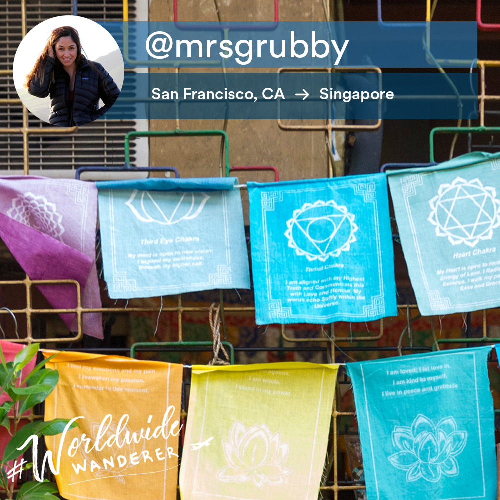 This is a photo of colorful hanging cloths with an overlay with an instagram handle.