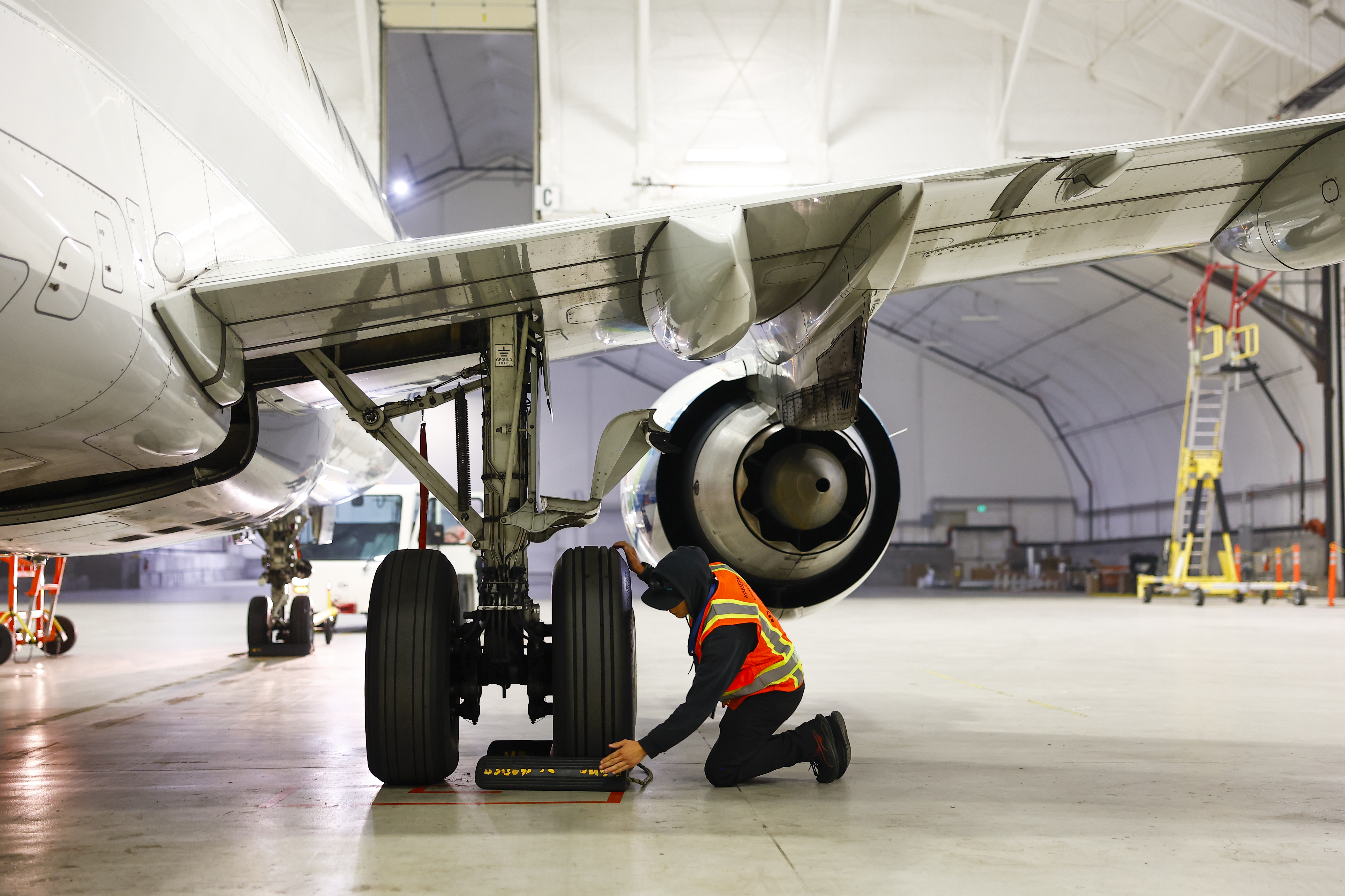 A mechanic inspects a plane in a hangar