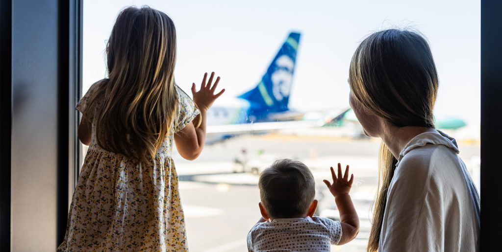 Family looking out window at Alaska Airlines aircraft