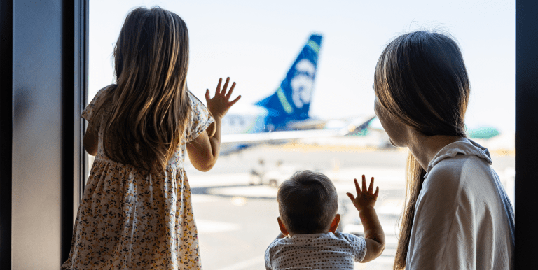 Family looking out window at Alaska Airlines aircraft