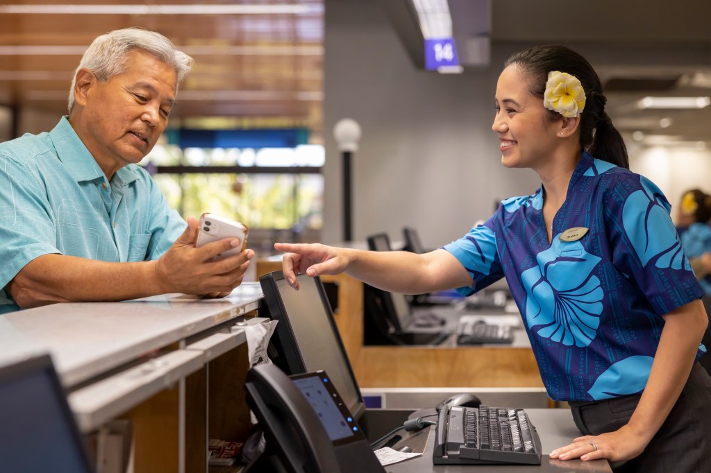 HAL Lobby, HNL, Guest Services HA Guest Service Agent assisting a customer