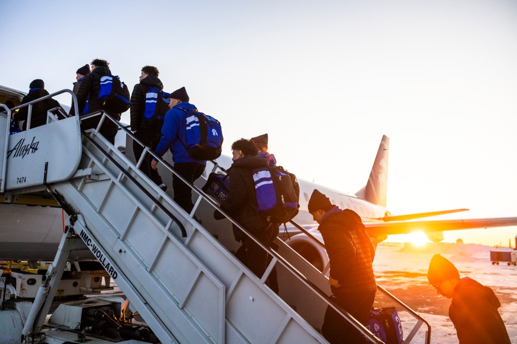 Nome athletes boarding aircraft