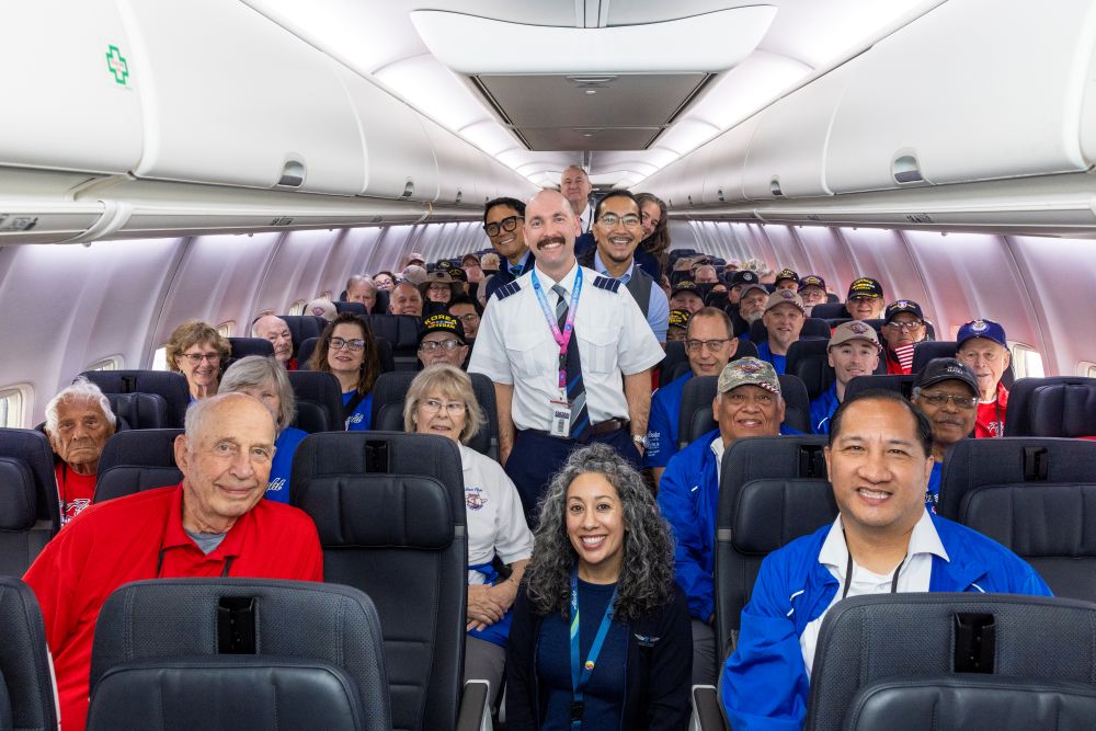 Nome basketball team in front of Alaska Airlines aircraft tail