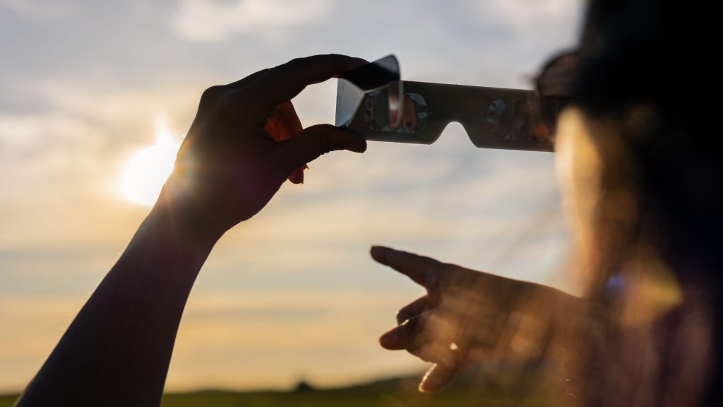 Person observing the eclipse with cardboard glasses