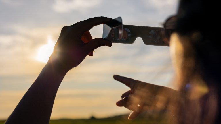 Person observing the eclipse with cardboard glasses