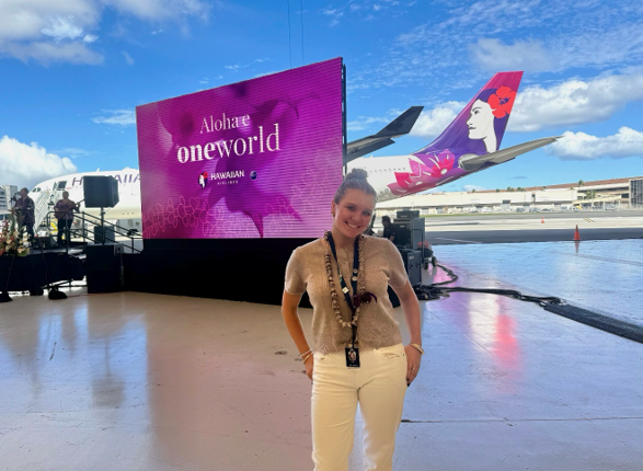 Image of intern standing in front of a oneworld event in HNL