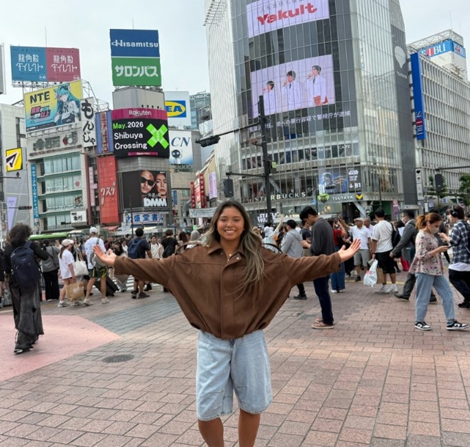 Image of intern standing in a street in Tokyo with her arms out