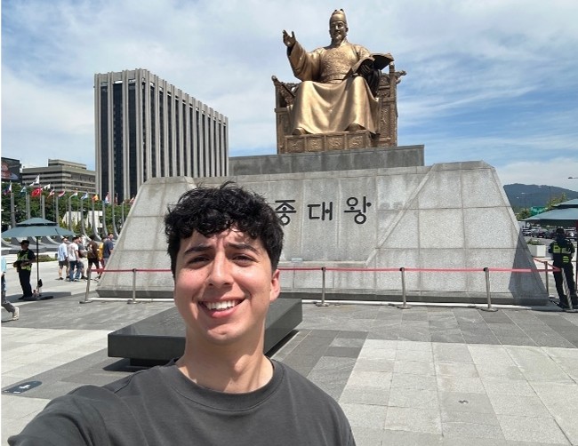 Image of intern taking a selfie in front of the Statue of King Sejong the Great in Seoul