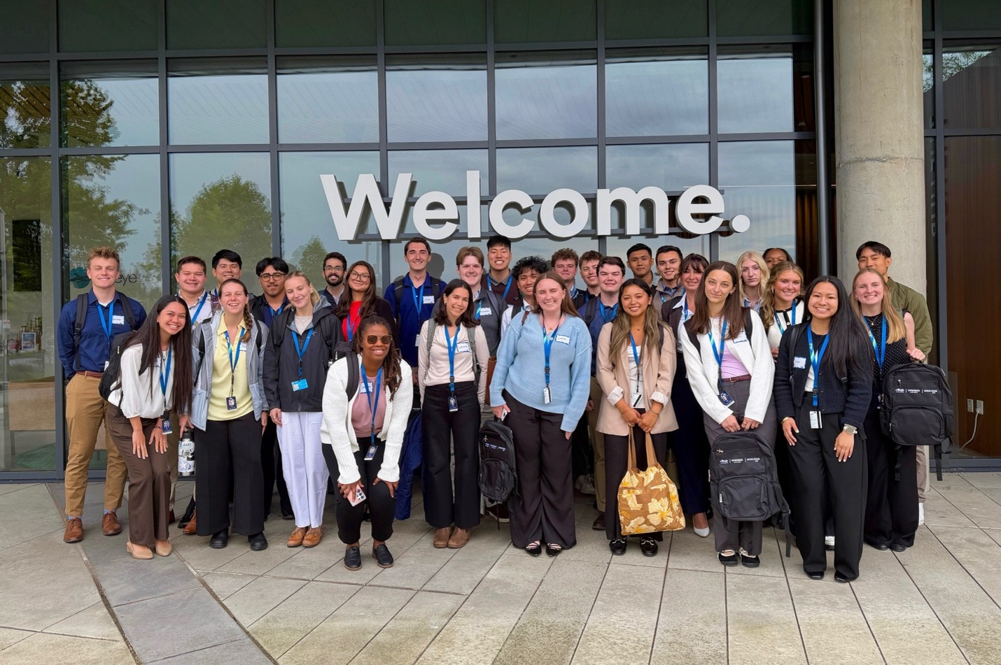 Image of the intern group standing outside of a welcome sign