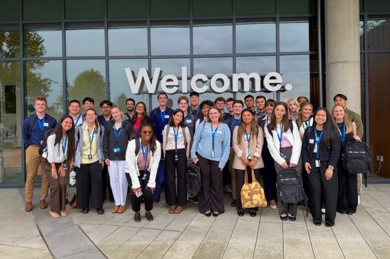 Image of the intern group standing outside of a welcome sign